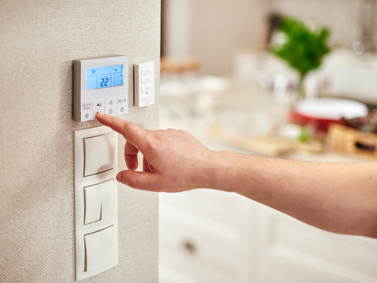 Digitaler Thermostat an einer Wohnzimmerwand über den die Wärme- und Energietechnikanlage gesteuert wird.